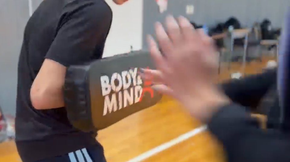 A branded Body & Mind striking pad being hit