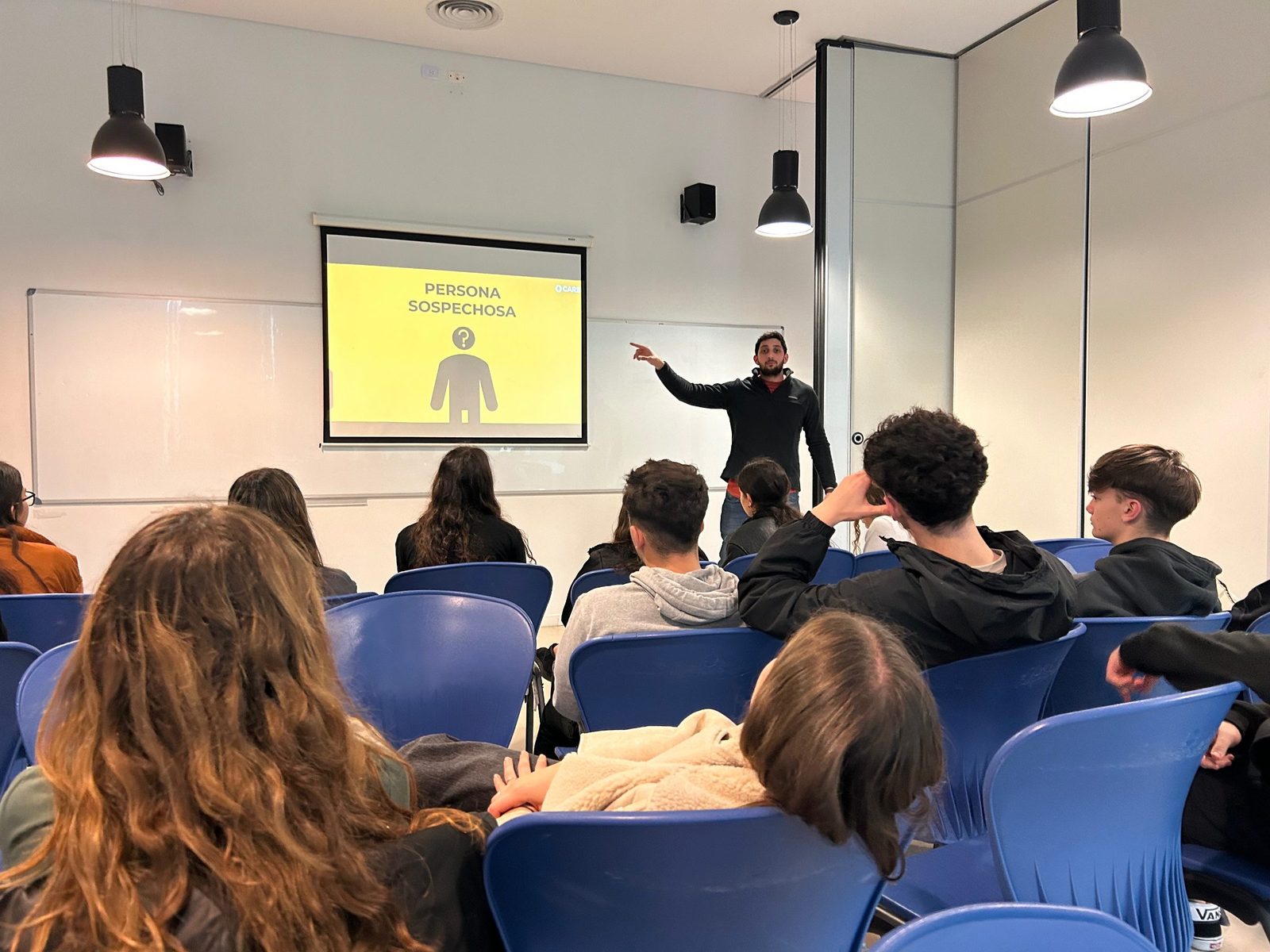 A CARE awareness session with students, projected slide in the background